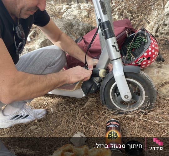 אדם מתקן קורקינט עם כלי עבודה